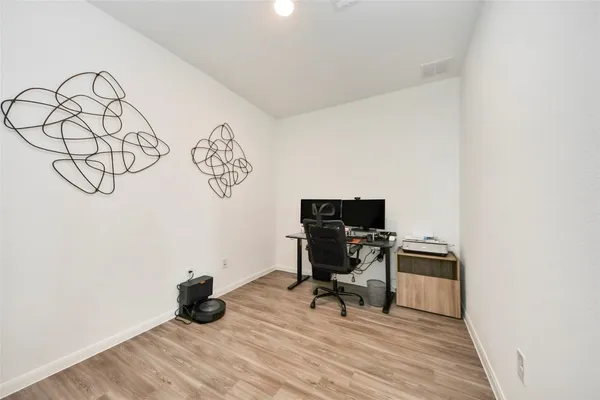 a view of work space with wooden floor and a window