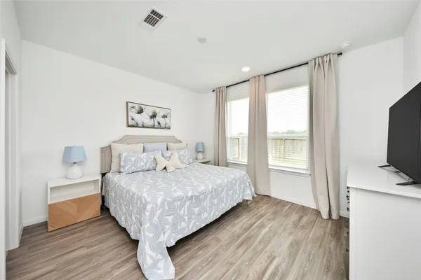 a bed sitting in a spacious bedroom next to a window