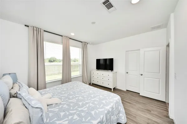 a bedroom with a bed and a flat screen tv