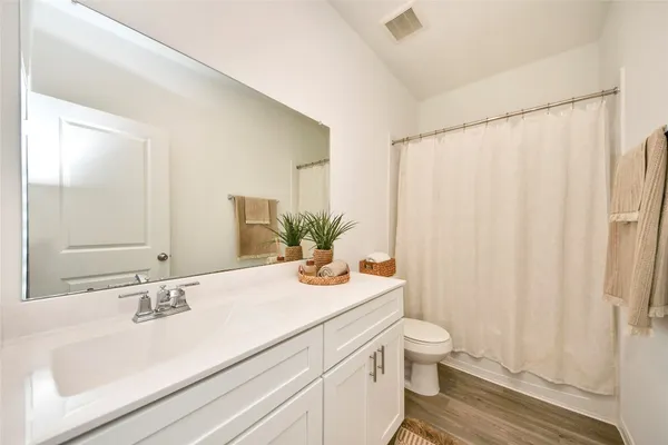 a bathroom with a granite countertop sink a toilet and a large mirror