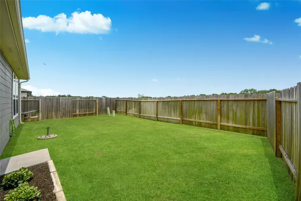 a view of a green field with wooden fence