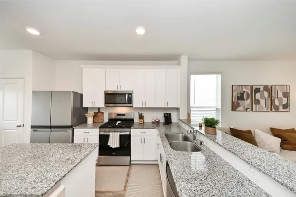 a kitchen with granite countertop lots of counter top space and stainless steel appliances