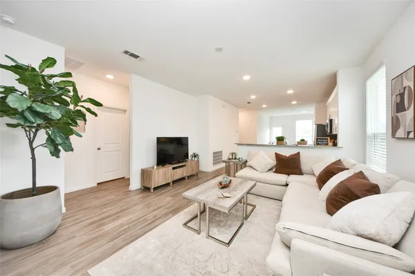 a living room with furniture potted plant and a flat screen tv