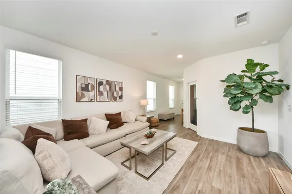 a living room with furniture potted plant and a window