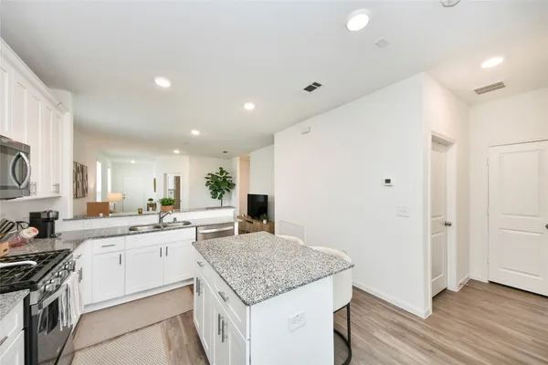 a kitchen with a sink a stove a refrigerator and cabinets