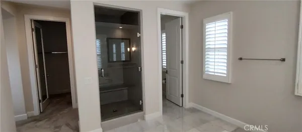 a view of an empty room with closet and a window