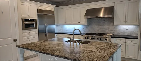a kitchen with stainless steel appliances granite countertop a sink stove and microwave