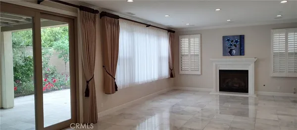 a view of an empty room with a fireplace and a window