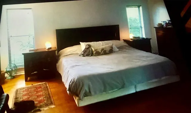 a bed sitting in a bedroom next to a window