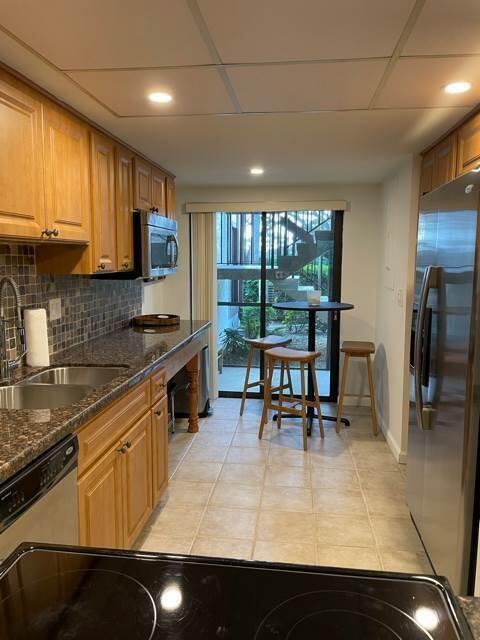 13400 Polo Road West Wellington, FL 33414 - Photo 5 of 16 a kitchen with stainless steel appliances granite countertop a stove a sink a microwave and a refrigerator