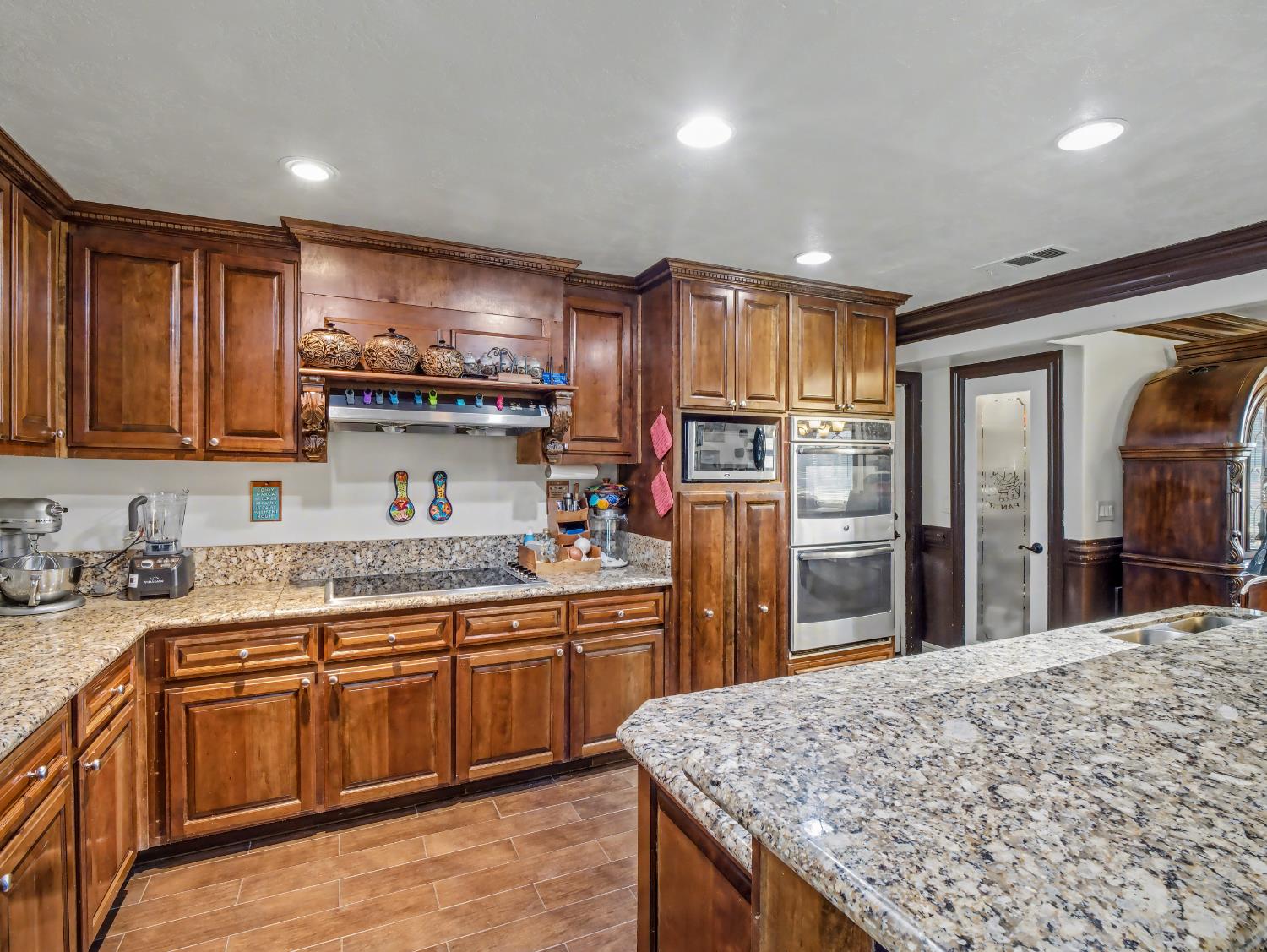 16998 Rio Plaza Road Madera, CA 93636 - Photo 12 of 42 a kitchen with stainless steel appliances granite countertop wooden cabinets a sink and dishwasher