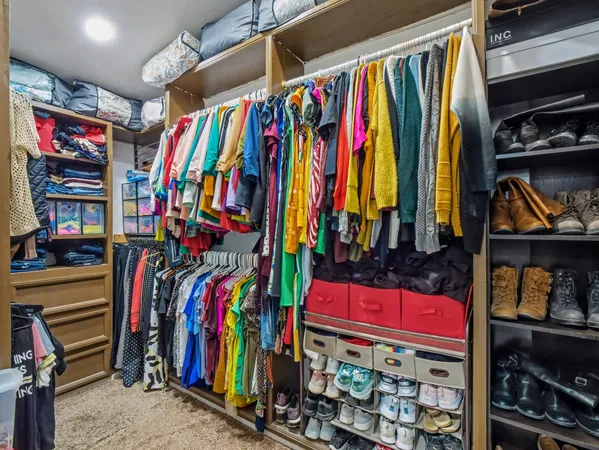 a view of walk in closet with clothes