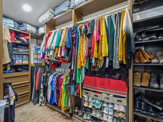a view of walk in closet with clothes