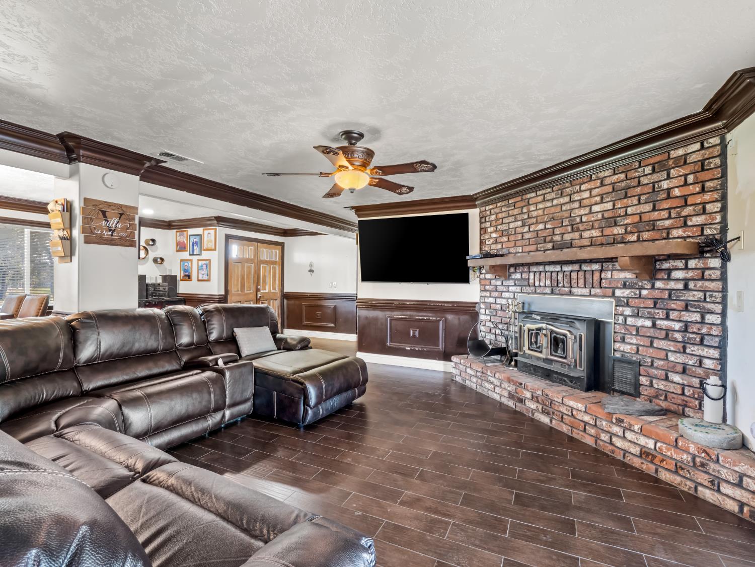16998 Rio Plaza Road Madera, CA 93636 - Photo 4 of 42 a living room with furniture a fireplace and a flat screen tv