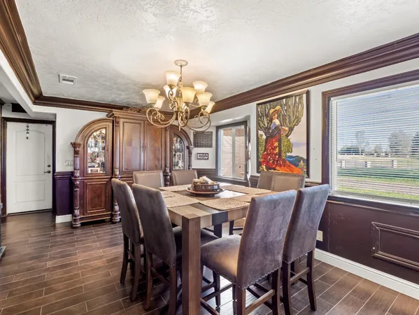 a view of a dining room with furniture a chandelier and wooden floor