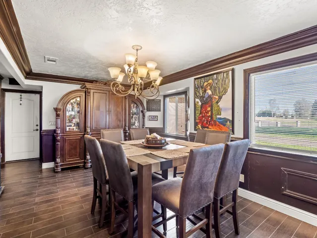 a view of a dining room with furniture a chandelier and wooden floor