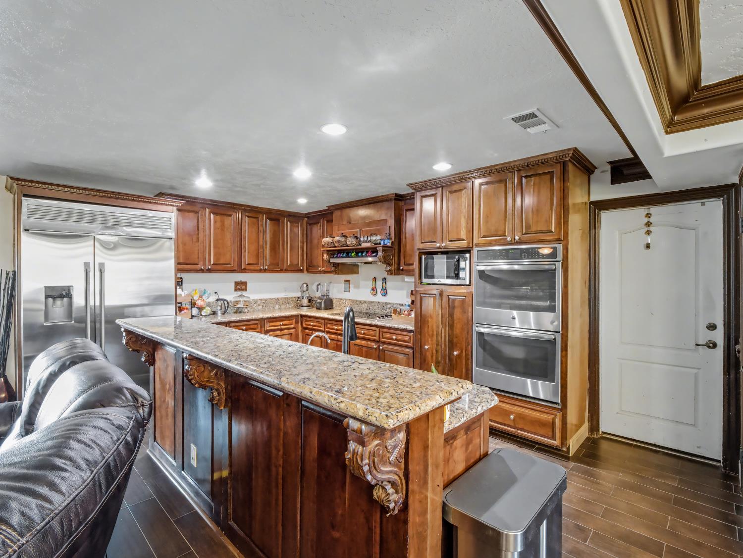 16998 Rio Plaza Road Madera, CA 93636 - Photo 9 of 42 a kitchen with stainless steel appliances granite countertop a refrigerator a stove top oven a sink and dishwasher