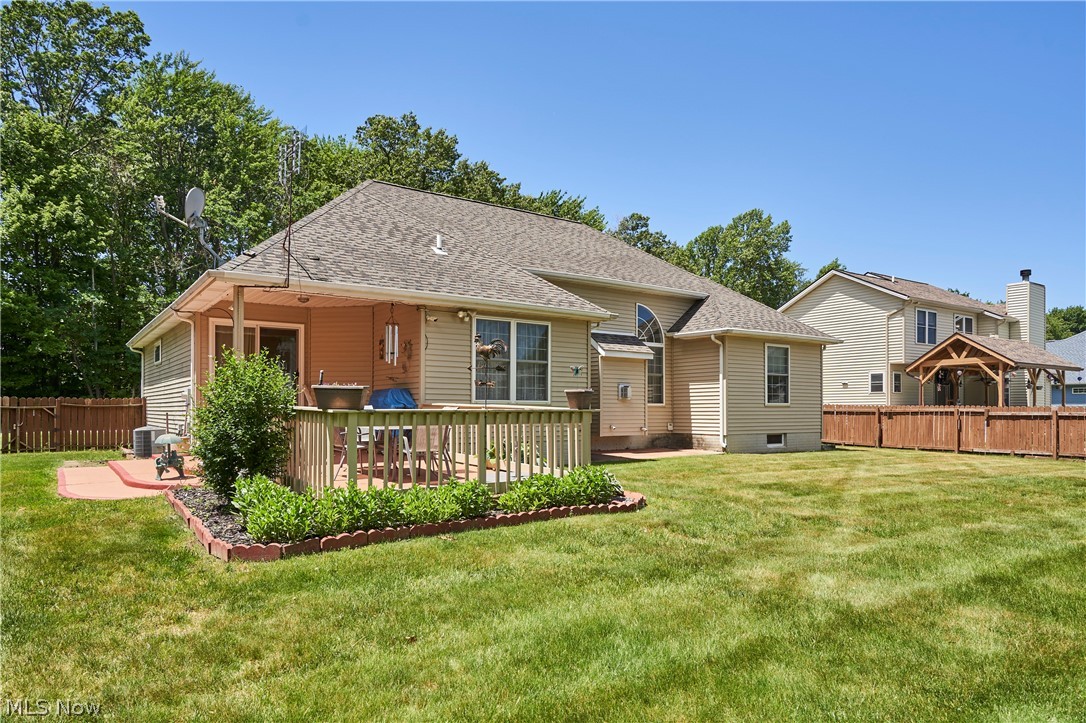 1963 Haines Road Madison, OH 44057 - Photo 29 of 34 Expansive backyard featuring a covered patio, a wooden deck with railing, and a brick paver patio