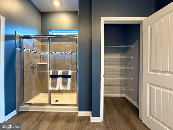 a room with wooden floor and a glass door shower