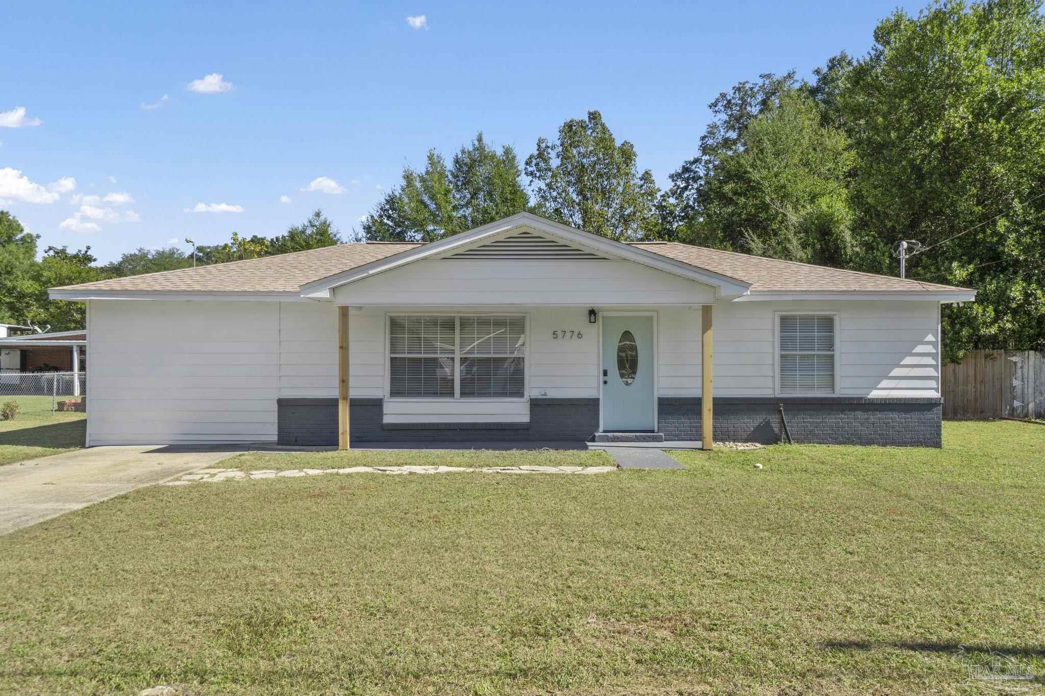 a view of a house with a yard and sitting area
