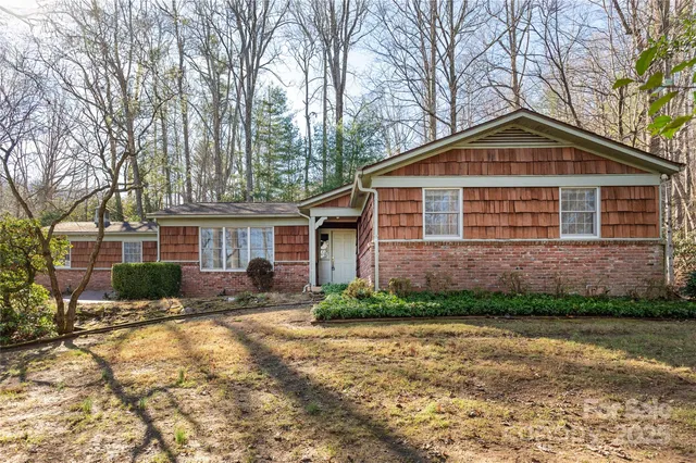 a front view of a house with a yard and trees