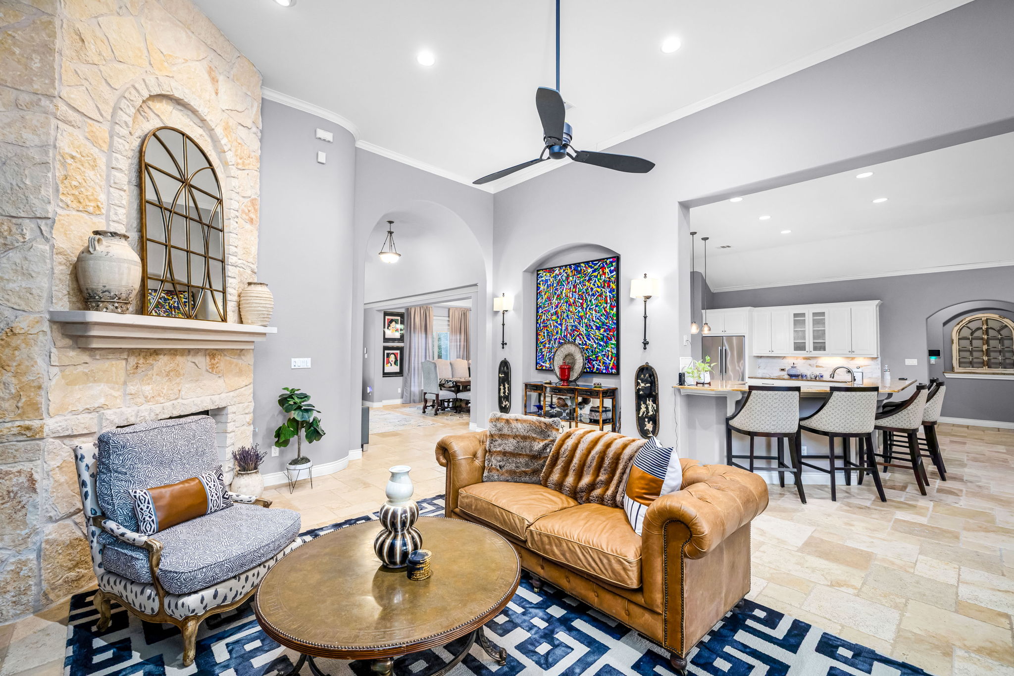11604 Shoreview Overlook Austin, TX 78732 - Photo 17 of 40 Living area featuring a stone fireplace, arched walkways, a high ceiling, a ceiling fan, and recessed lighting