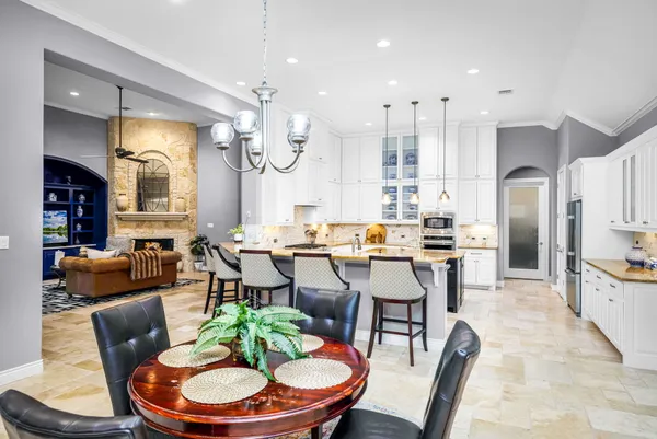 a view of a dining room with furniture a chandelier and wooden floor