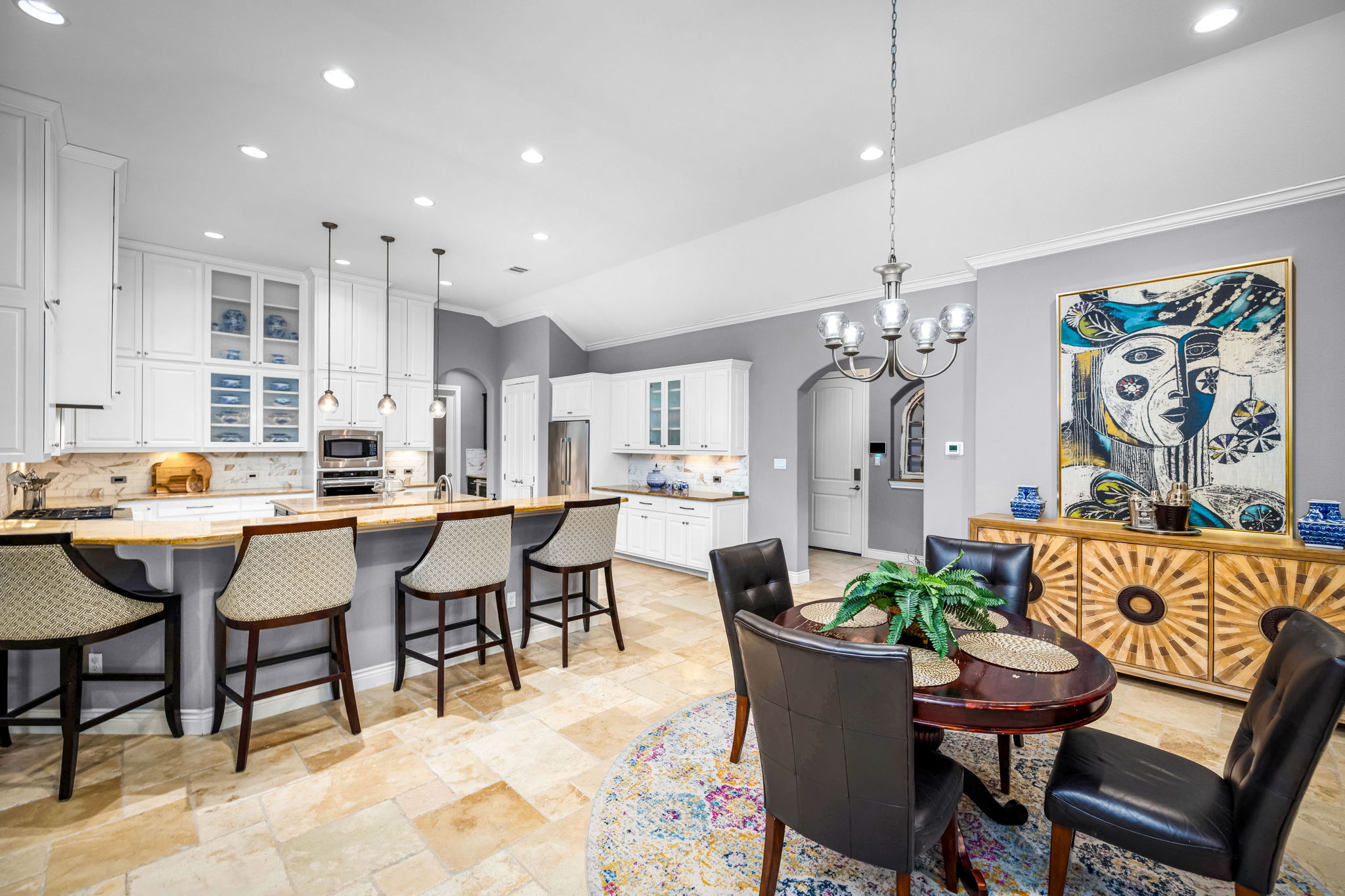 11604 Shoreview Overlook Austin, TX 78732 - Photo 28 of 40 Dining room featuring arched walkways, ornamental molding, hanging lights, light stone finish floors, and lofted ceiling