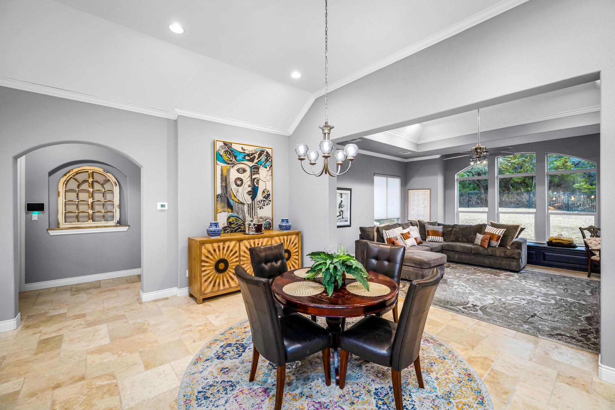 11604 Shoreview Overlook Austin, TX 78732 - Photo 29 of 40 Dining space featuring ornamental molding, vaulted ceiling, stone tile floors, arched walkways, and hanging lights