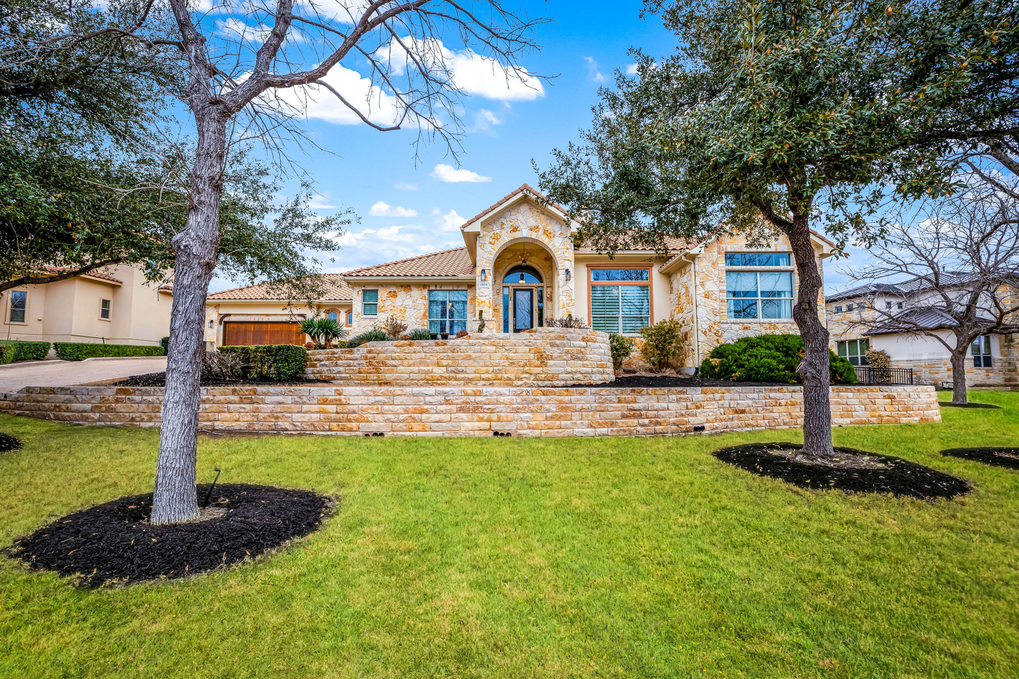 11604 Shoreview Overlook Austin, TX 78732 - Photo 6 of 40 Mediterranean / spanish house with stone siding, a front yard, stucco siding, a tiled roof, and a garage