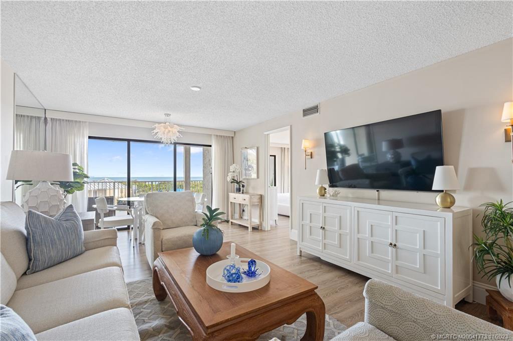 429 Northeast Tradewind Lane, Unit 2109 Stuart, FL 34996 - Photo 12 of 35 a living room with furniture a flat screen tv and a large window