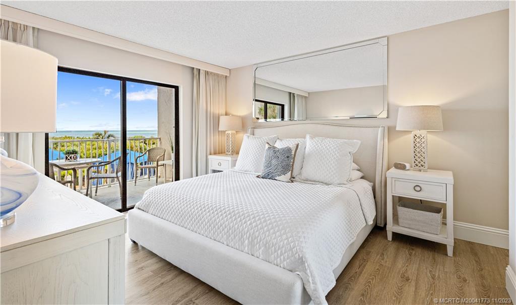 429 Northeast Tradewind Lane, Unit 2109 Stuart, FL 34996 - Photo 18 of 35 a bedroom with a bed and a large window