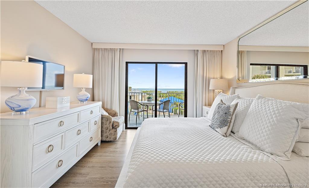 429 Northeast Tradewind Lane, Unit 2109 Stuart, FL 34996 - Photo 19 of 35 a bedroom with a bed and a large window