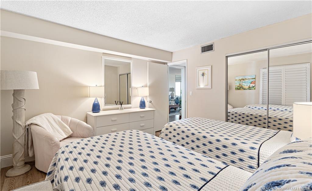 429 Northeast Tradewind Lane, Unit 2109 Stuart, FL 34996 - Photo 24 of 35 a bedroom with a bed and a lamp