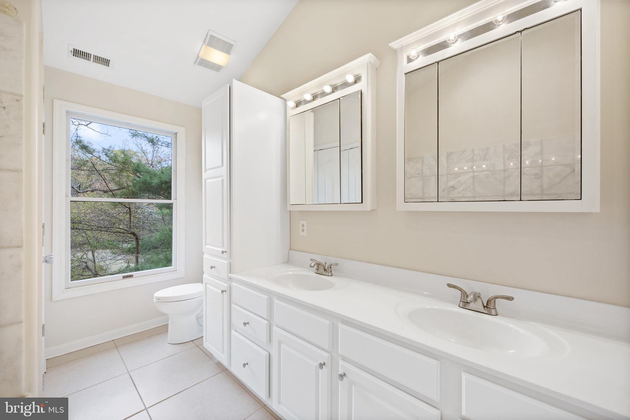 322 Piney Point Road Pasadena, MD 21122 - Photo 22 of 50 a bathroom with a double vanity sink a toilet and a mirror