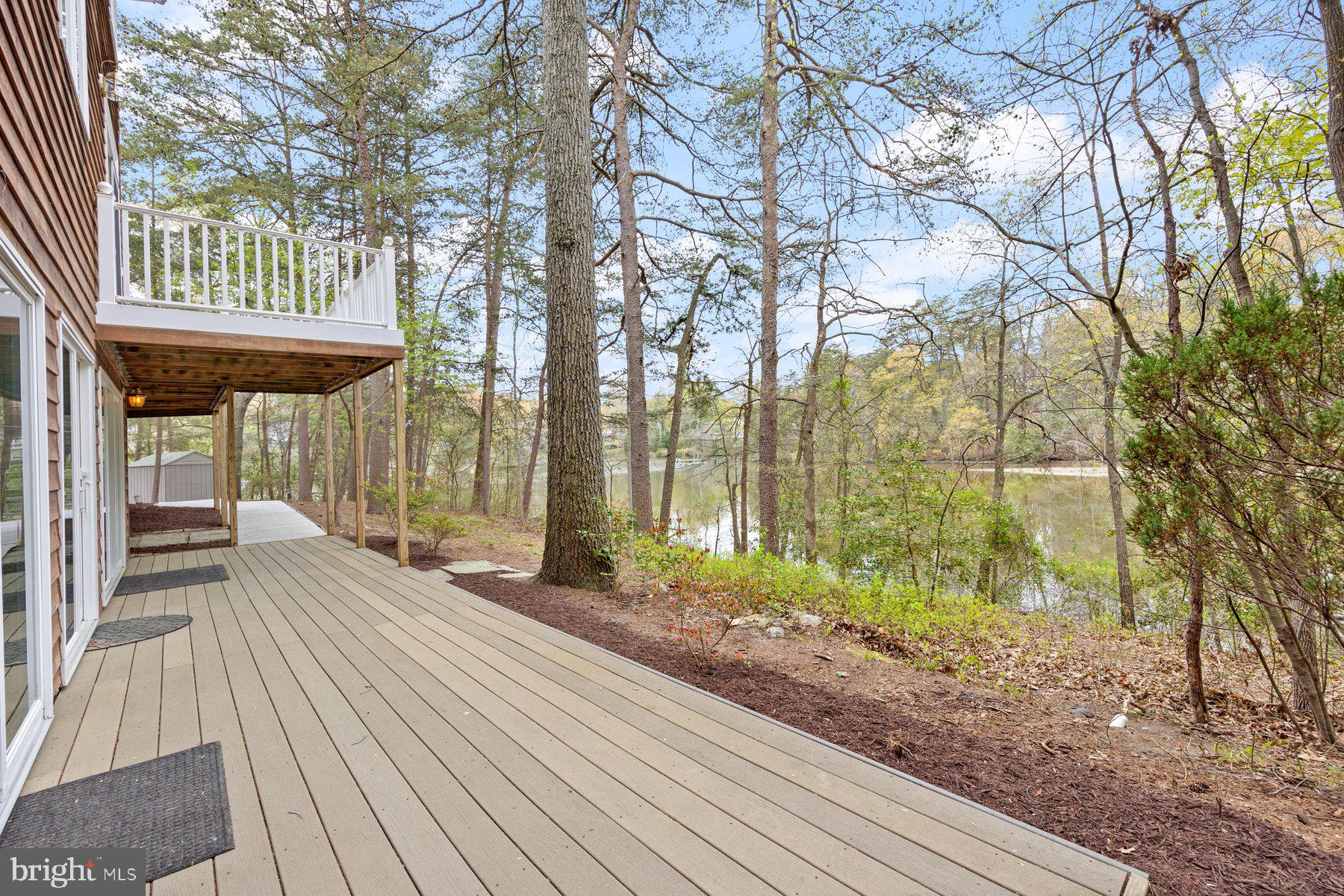 322 Piney Point Road Pasadena, MD 21122 - Photo 38 of 50 a backyard of a house with large trees and a wooden bench