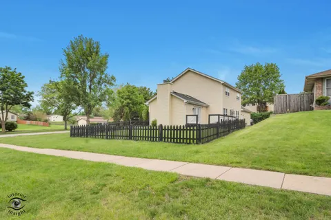 a view of a house with a big yard and large trees