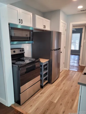 a kitchen with a refrigerator stove and wooden cabinets