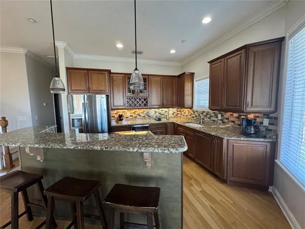 a kitchen with stainless steel appliances granite countertop a sink refrigerator and cabinets