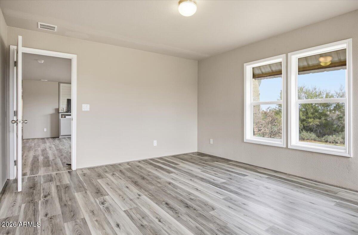 33597 South Davis Ranch Road Marana, AZ 85658 - Photo 18 of 48 a view of an empty room with wooden floor and a window
