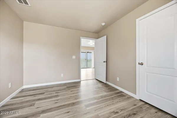 an empty room with wooden floor and window