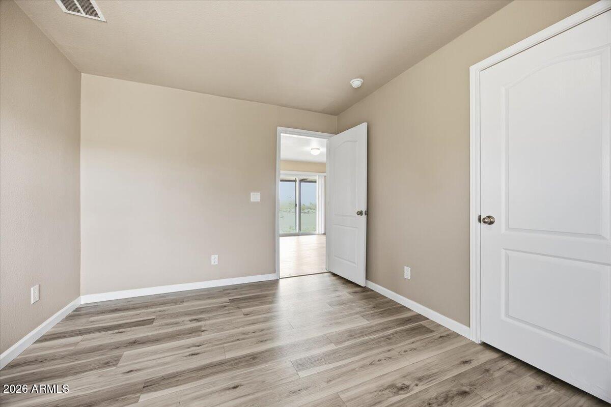 33597 South Davis Ranch Road Marana, AZ 85658 - Photo 28 of 48 a view of an empty room with wooden floor and a window