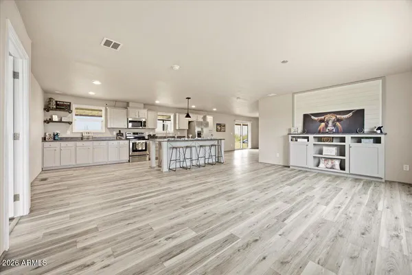 a kitchen with stainless steel appliances wooden floor and large windows