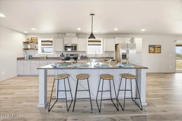 a kitchen with granite countertop a table chairs stove a sink and dishwasher