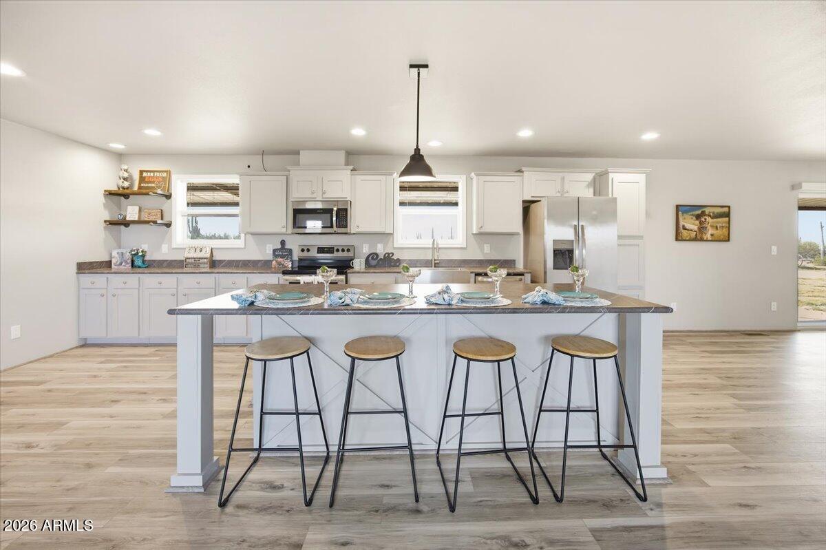 33597 South Davis Ranch Road Marana, AZ 85658 - Photo 9 of 48 a kitchen with granite countertop a table chairs stove a sink and dishwasher