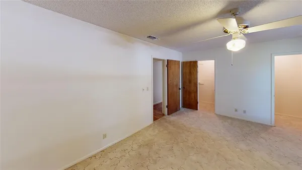 an empty room with a mirror and a fan