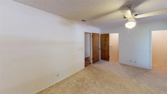 an empty room with a mirror and a fan