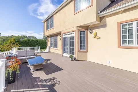 a view of a patio with couches chairs and wooden floor