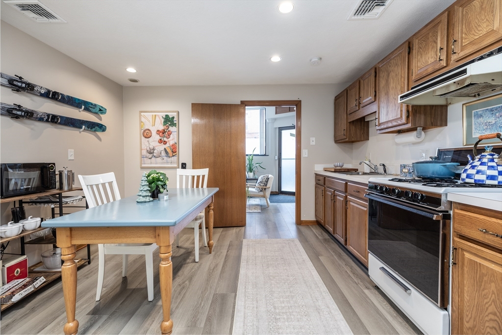 265 North Street, Unit A Boston, MA 02113 - Photo 8 of 17 a kitchen with stainless steel appliances kitchen island granite countertop a stove a sink dishwasher and a refrigerator with wooden floor