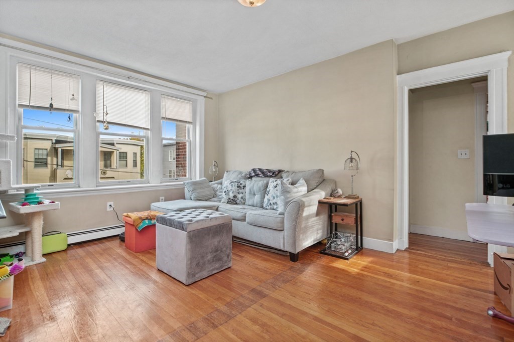 a living room with furniture and a wooden floor